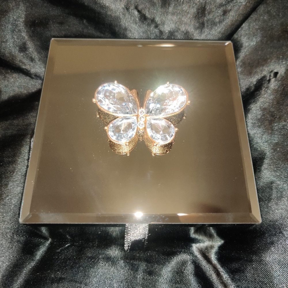 Mirrored jewelry box with rhinestone butterfly.